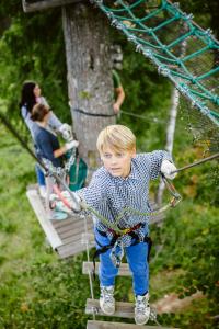 a young boy on a zip line with a parrot at Kempings Ozolkalns in Cēsis
