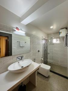 bagno bianco con lavandino e doccia di Fratelli Guest House a Shillong