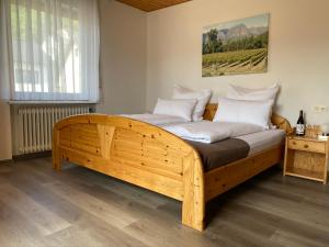 a bedroom with a wooden bed with white pillows at Weingut H. Gindorf in Lieser