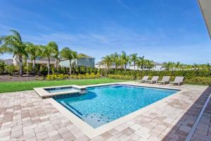- une piscine avec 2 chaises longues dans la cour dans l'établissement 8 Bedroom Vacation Home with Pool 2114, à Orlando