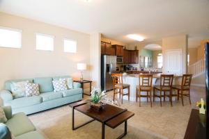 a living room with a blue couch and a kitchen at Solterra Resort 5 Bedroom Vacation Home with Pool 1604 in Davenport