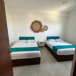 a bedroom with two beds and a mirror on the wall at Condominio Aeromar in Acapulco