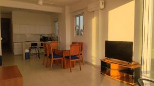 Condominio Aeromar في أكابولكو: غرفة معيشة مع طاولة مع كراسي وتلفزيون