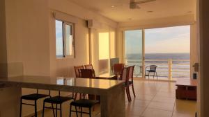eine Küche mit einem Tisch und Stühlen sowie Meerblick in der Unterkunft Condominio Aeromar in Acapulco