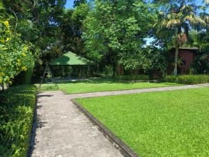 Chai Seeds Resort في Mākum: ممشى في ساحة مع حديقة خضراء