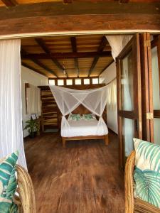 a bedroom with a bed with a mosquito net at CAFE MAYA in Zipolite