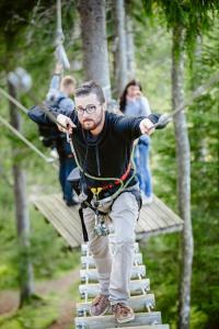 a man on a zip line in the forest at Kempings Ozolkalns in Cēsis