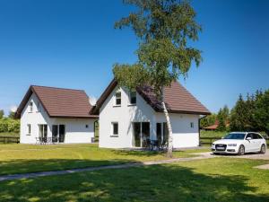 a house with a car parked in front of it at Brick Cottage near Baltic Sea and Windmill in Lędzin