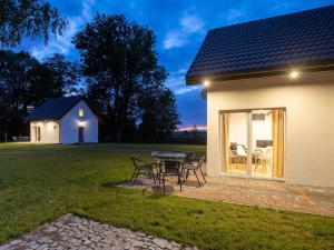 a house with a table and chairs in a yard at Comfortable holiday homes for 4 people in Lędzin