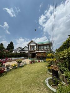 a house with a lawn in front of it at Fratelli Guest House in Shillong