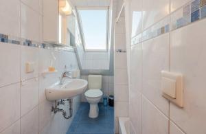a white bathroom with a sink and a toilet at DZ 11 Doppelzimmer in Heringsdorf