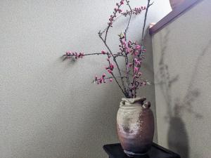 Un jarrón con flores rosas sobre una mesa. en FarmStayINN 母屋 Sanzaemon-tei GuestHouse Second floor Shiga-Takasima Traditional Japanese architecture house Limited to one group per day, en Takashima