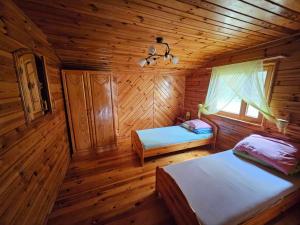 1 dormitorio con 2 camas en una cabaña de madera en Drzemalik wypoczywaj z KLASĄ, en Mikołajki Pomorskie