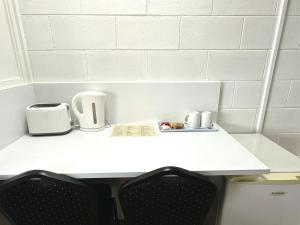 a white table with two toasters on top of it at Sawmill Hotel Motel in Wondai