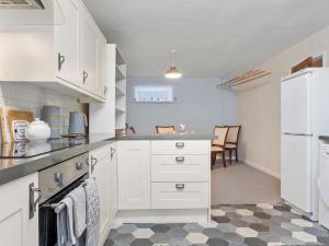 een keuken met witte kasten en een zwart-witte vloer bij Miterdale A Wonderful Home in the Idyllic Duddon Valley in Broughton in Furness