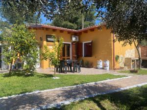 una casa amarilla con una mesa en el patio en Casa vacanze Shardana, en Iglesias