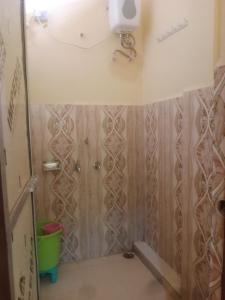 La salle de bains est pourvue d'une douche et de murs en bois. dans l'établissement Aanand Bhwan, à Ayodhya