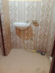 La salle de bains est pourvue d'un lavabo et d'un tuyau. dans l'établissement Aanand Bhwan, à Ayodhya