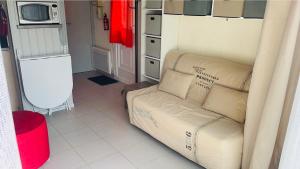 ein Wohnzimmer mit einem Sofa und einer Mikrowelle in der Unterkunft La Coccinelle YourHostHelper in Gujan-Mestras