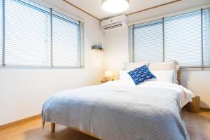 Ένα ή περισσότερα κρεβάτια σε δωμάτιο στο 1棟家貸し切り！潮騒の中で異国情緒溢れるリゾート地「北谷」を満喫：）