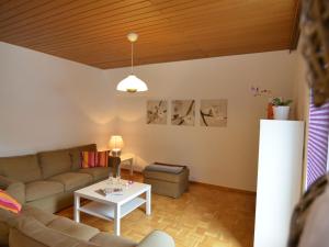 ein Wohnzimmer mit einem Sofa und einem Tisch in der Unterkunft Spacious apartment in Weser Uplands with garden in Bad Pyrmont