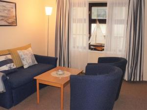 ヴィスマールにあるModern Apartment in Wismar near Seaのリビングルーム(ソファ、椅子、テーブル付)