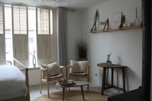 1 dormitorio con 1 cama, 2 sillas y mesa en Casa By Sil's, en Colijnsplaat