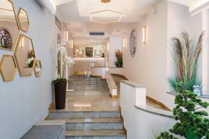 un couloir avec des escaliers et des plantes dans un bâtiment dans l'établissement Hotel Marco Polo, à Lido di Jesolo