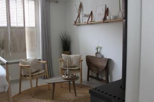 sala de estar con 2 sillas y mesa en Casa By Sil's, en Colijnsplaat