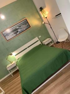 zielone łóżko w pokoju z zieloną ścianą w obiekcie Lemontreeqse w mieście Quartu SantʼElena