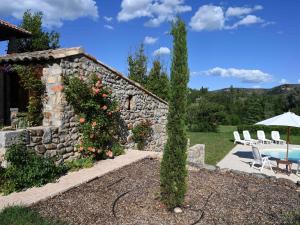 a garden with a stone wall and a swimming pool at Restful Villa in Largenti re with Swimming Pool in Montréal