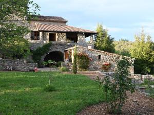 a stone house with a stone wall and a yard at Restful Villa in Largenti re with Swimming Pool in Montréal