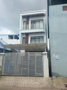un edificio blanco con una puerta delante en Peaceful Homestay en Sihanoukville