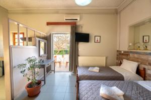 a bedroom with two beds and a table with a plant at Bikakis Family Apartments in Kissamos