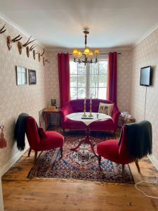 sala de estar con sofá rojo y 2 sillas en Moholms Herrgård, en Moholm