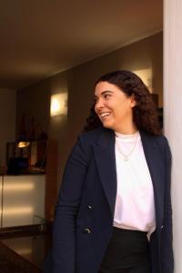a woman in a suit is smiling in a room at Residenza Agnello D'Oro in Bussolengo
