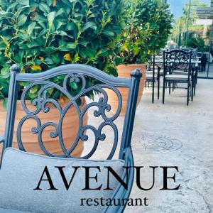 a bench with the words avenue restaurant on it at Hotel AVENUE in Ravda