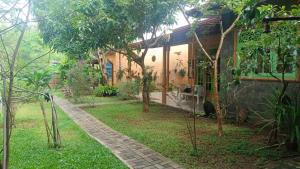 a house with a walkway next to a yard at Dhee Ayurved Resort Hospital in Malabe