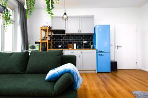 a living room with a green couch and a blue refrigerator at Kernsaniert-Küche-Parkplatz-Designerbad-Netflix in Leipzig