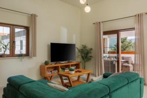 a living room with a green couch and a tv at Villa Alora in Pridraga