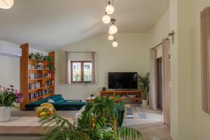 a living room with a couch and a tv at Villa Alora in Pridraga