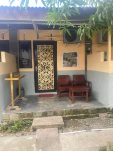 un edificio con una cruz y una puerta de madera en Maharani Homestay, en Gorontalo