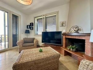 ein Wohnzimmer mit einem TV und einem Kamin in der Unterkunft Villa Desìo in Donnalucata