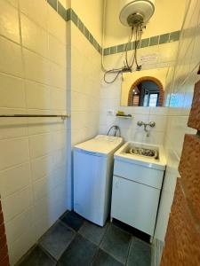y baño con lavadora y lavamanos. en Villa Desìo, en Donnalucata