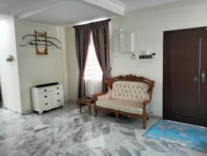 ein Wohnzimmer mit einem Stuhl und einem Fenster in der Unterkunft Villa Senitaman Organik in Seremban