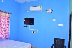 a blue room with a bed and a air conditioner at Hotel KIRITHI AC & RESIDENCY in Kurinjippādi