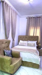1 dormitorio con 1 cama grande y 1 sofá en Blueocean.cog Apartments, en Benin City