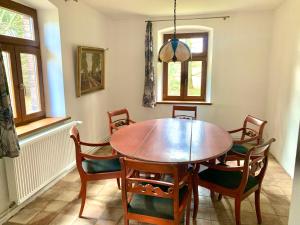 a dining room with a wooden table and chairs at Folwark Sudecki in Marciszów +15 photos