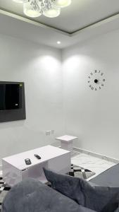 a white room with a table and a clock on the wall at Blueocean.cog Apartments in Benin City