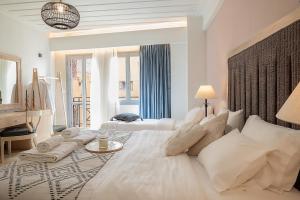 a white bedroom with a large bed and a desk at Vranas Ambiance Hotel in Chania Town